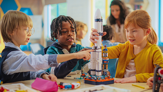 Drei Kinder bauen eine Weltraumrakete.