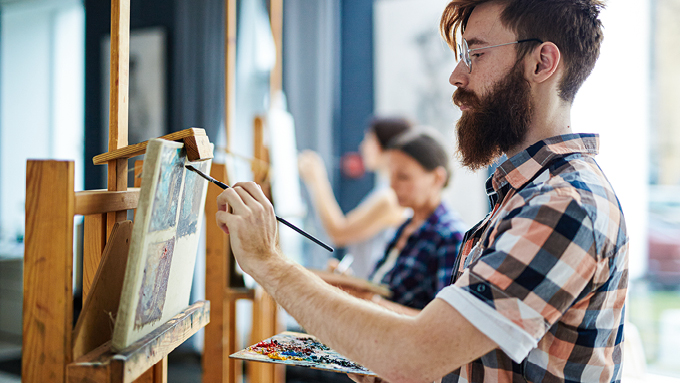 Eine Person malt an einer Stafelei.